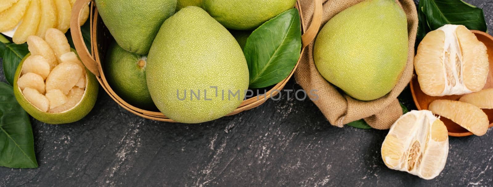 Fresh pomelo, pummelo, grapefruit, shaddock on black background, fruit for Mid-autumn festival, top view, flat lay.