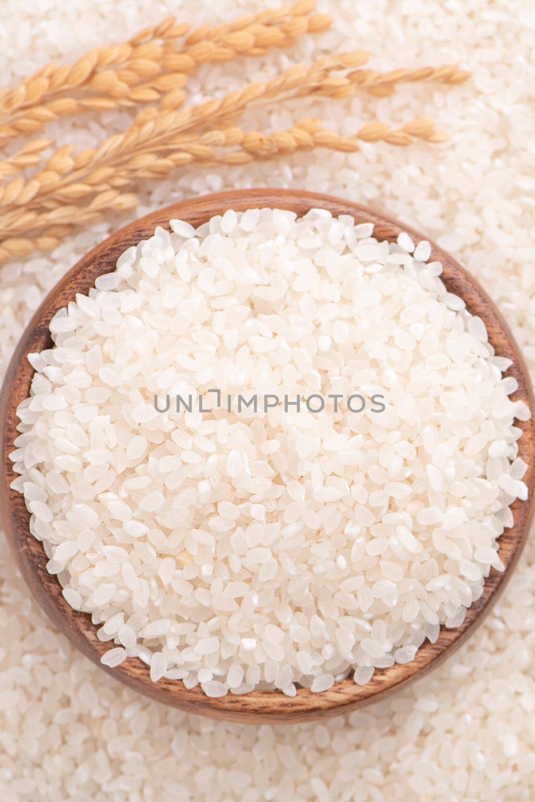 Raw rice in a bowl and full frame in the white background table, top view overhead shot, close up