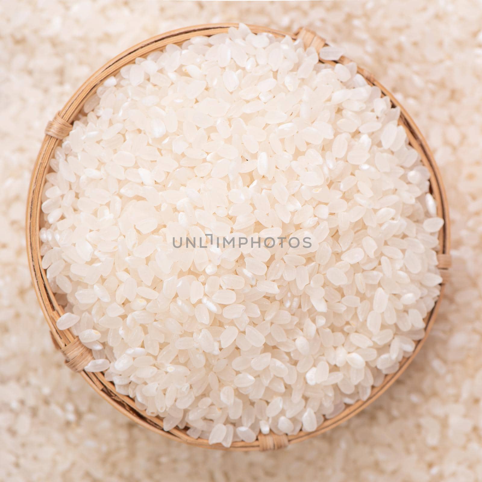 Raw rice in a bowl and full frame in the white background table, top view overhead shot, close up