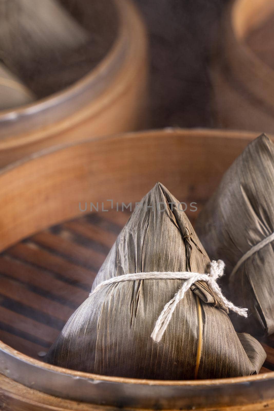 Rice dumpling, zongzi - Chinese rice dumpling zongzi on black brick background slate table, concept of Dragon Boat Festival traditional food, close up.