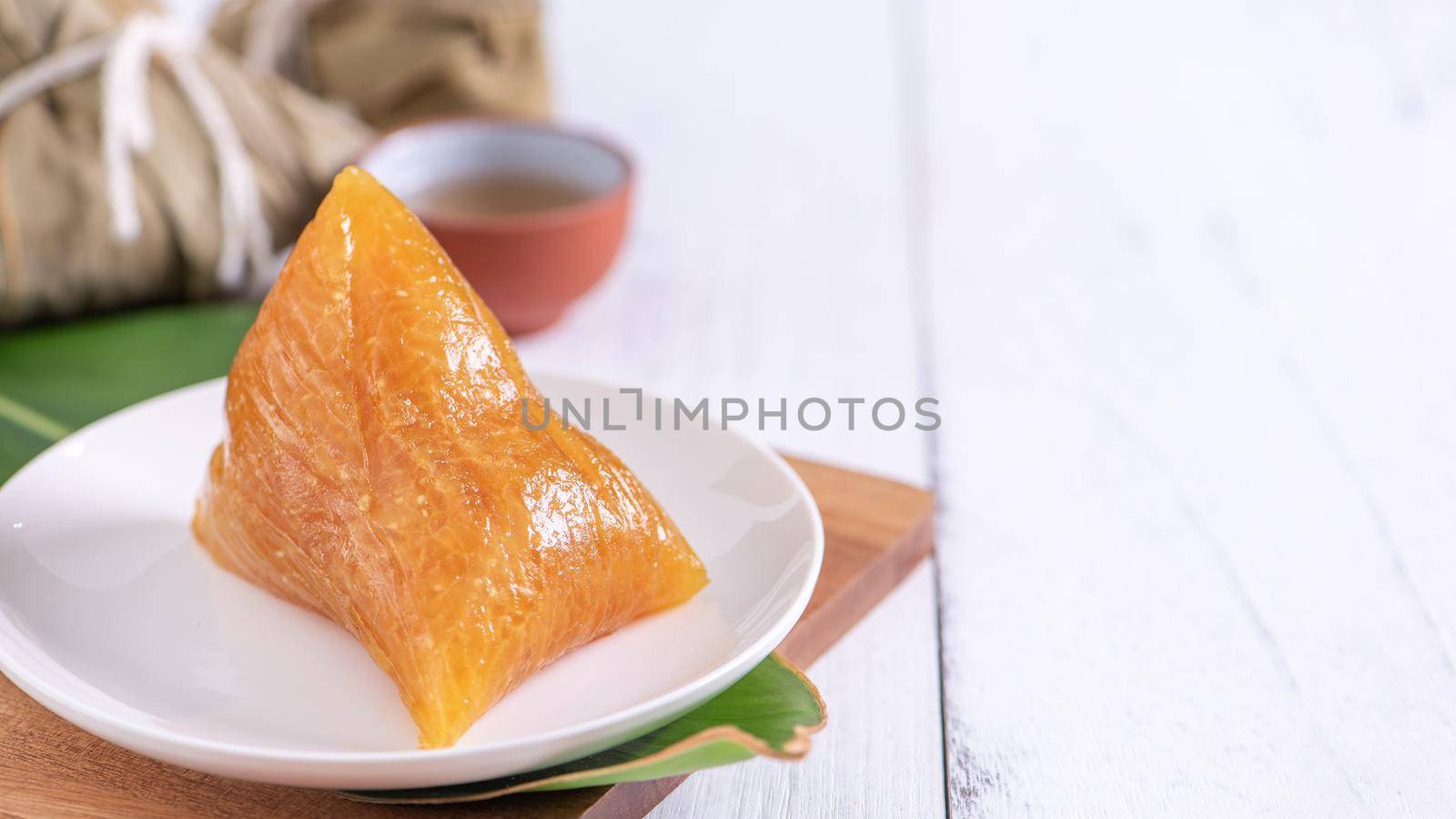 Zongzi - Alkaline rice dumpling - Traditional sweet Chinese crystal food on a plate to eat for Dragon Boat Duanwu Festival celebration concept, close up.