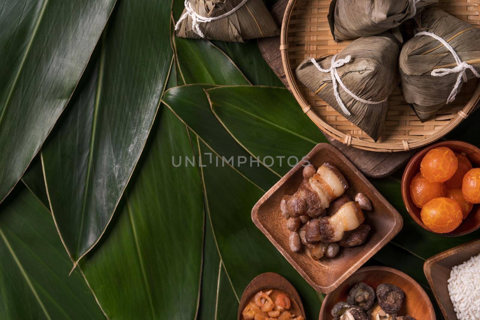 Rice dumpling, zongzi - Traditional Chinese food on green leaf background of Dragon Boat Festival, Duanwu Festival, top view, flat lay design concept.
