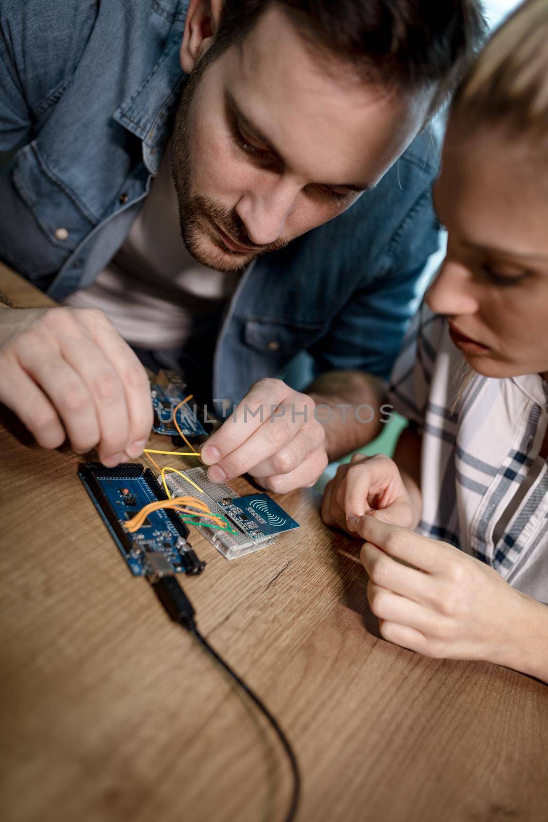 Two young colleagues technician focused on the repair of electronic equipment.