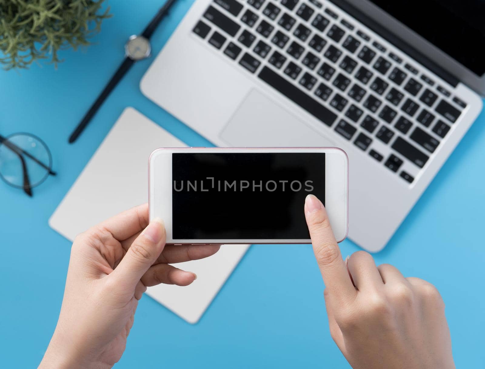 Social network connecting office table concept with fashion accessories, minimal interior with a woman holding smartphone, top view, flat lay, mockup, copy space