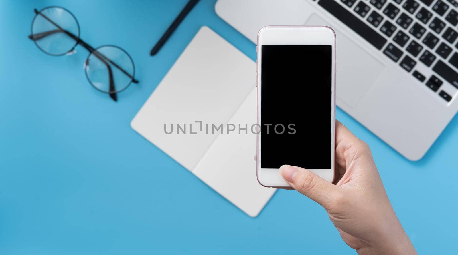 Social network connecting office table concept with fashion accessories, minimal interior with a woman holding smartphone, top view, flat lay, mockup, copy space