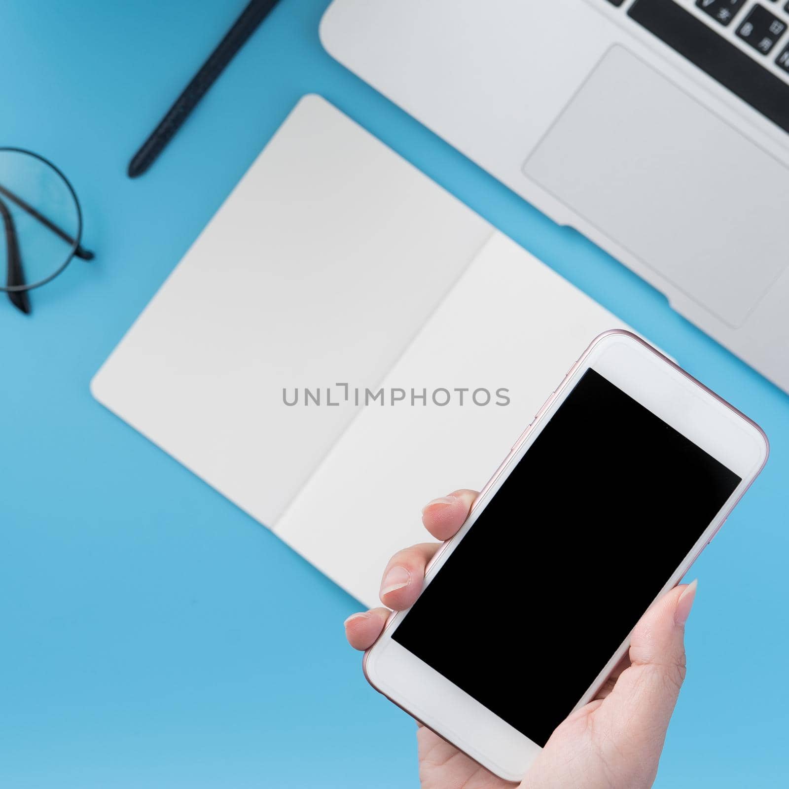 Social network connecting office table concept with fashion accessories, minimal interior with a woman holding smartphone, top view, flat lay, mockup, copy space