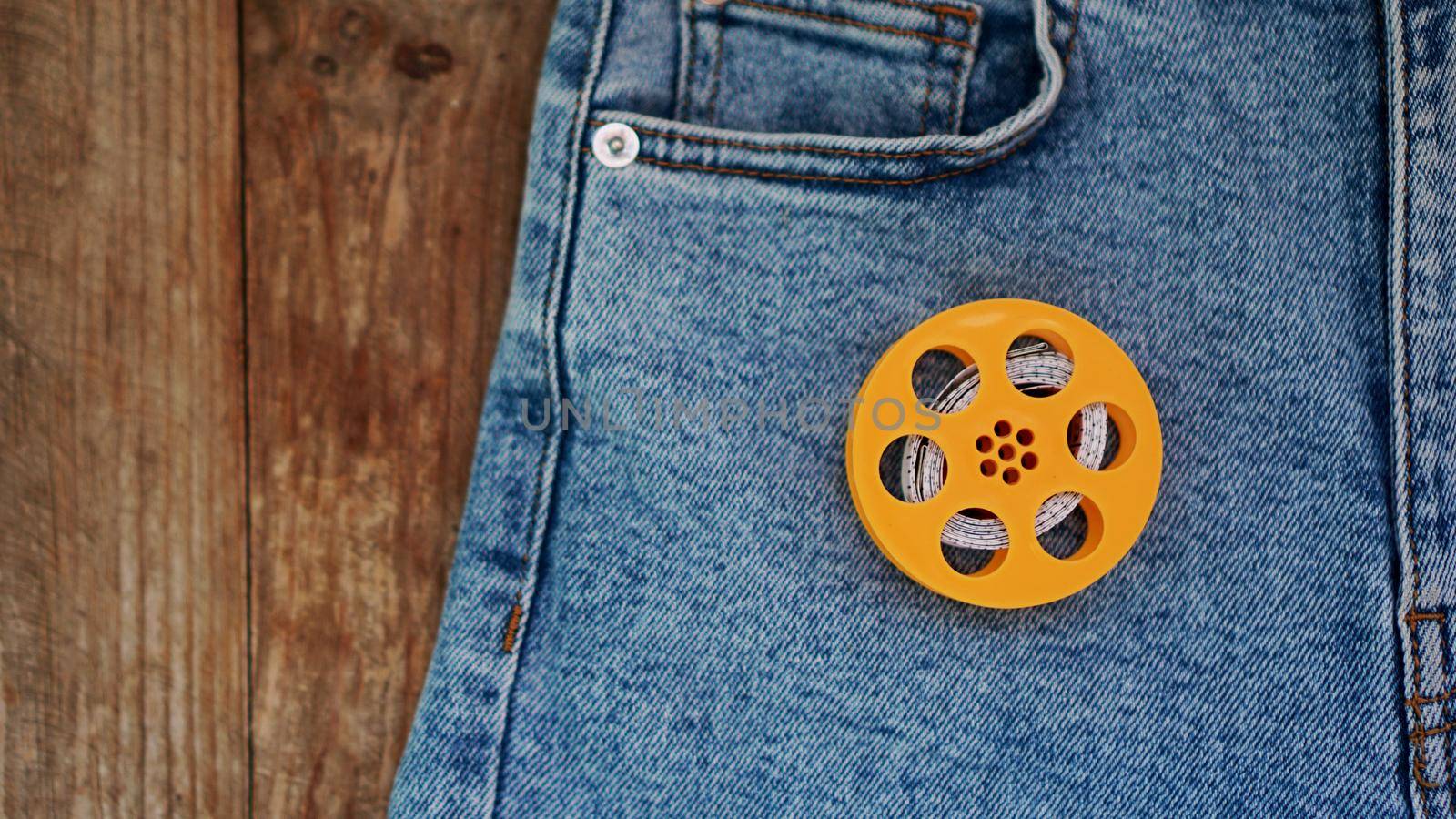 Blue jeans and a measuring tape. Slimming or sewing denim concept. Jeans on wooden background