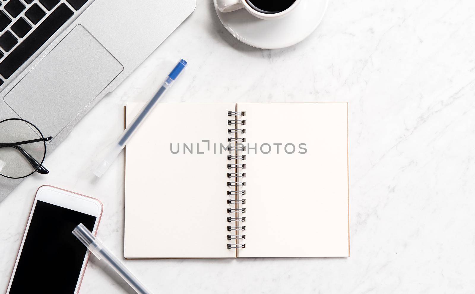 Stylized marble office working desk with smartphone, laptop, glasses and coffee, workspace design, mock up, topview, flatlay, copyspace, closeup