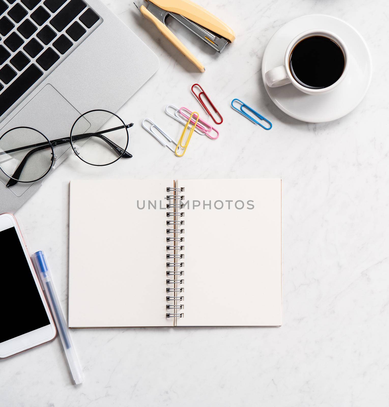 Stylized marble office working desk with smartphone, laptop, glasses and coffee, workspace design, mock up, topview, flatlay, copyspace, closeup