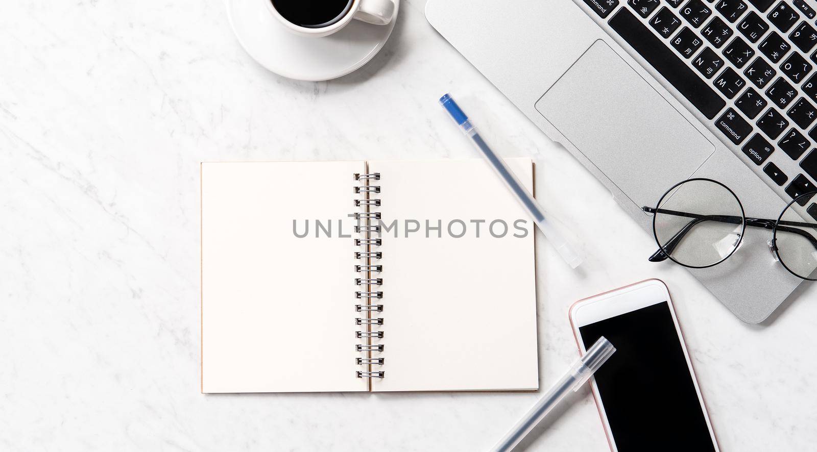 Stylized marble office working desk with smartphone, laptop, glasses and coffee, workspace design, mock up, topview, flatlay, copyspace, closeup