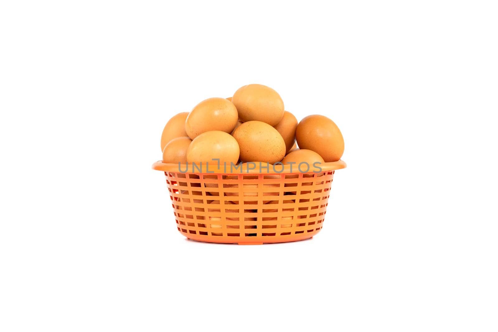 Group of eggs in an orange plastic basket isolated on white background