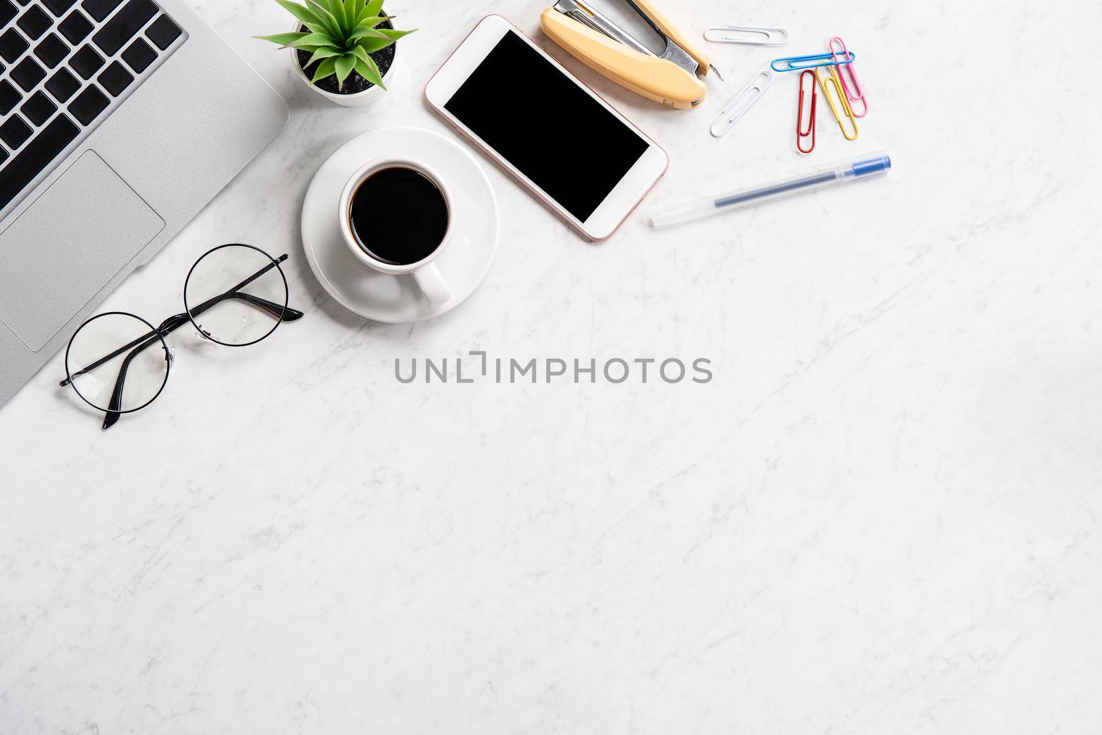 Stylized marble office working desk with smartphone, laptop, glasses and coffee, workspace design, mock up, topview, flatlay, copyspace, closeup