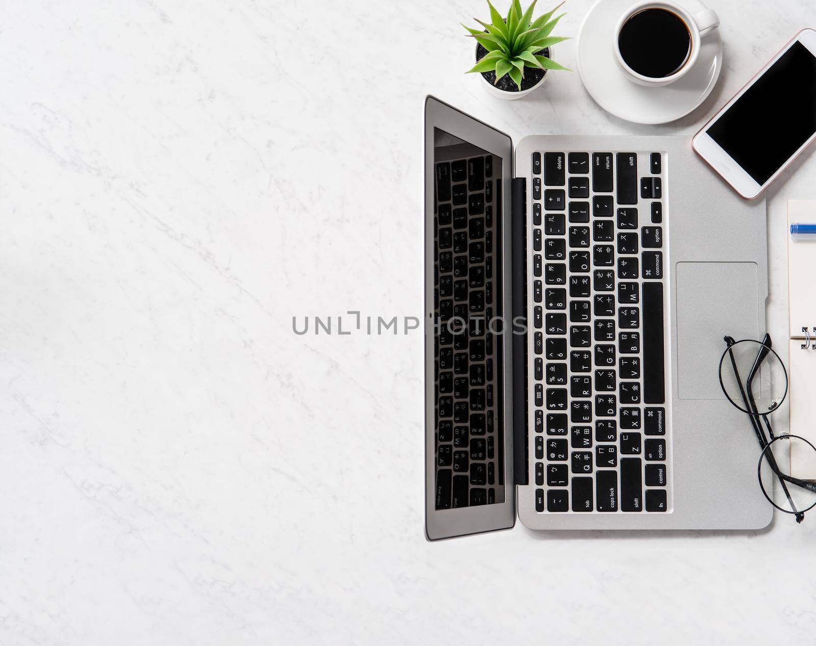 Stylized marble office working desk with smartphone, laptop, glasses and coffee, workspace design, mock up, topview, flatlay, copyspace, closeup