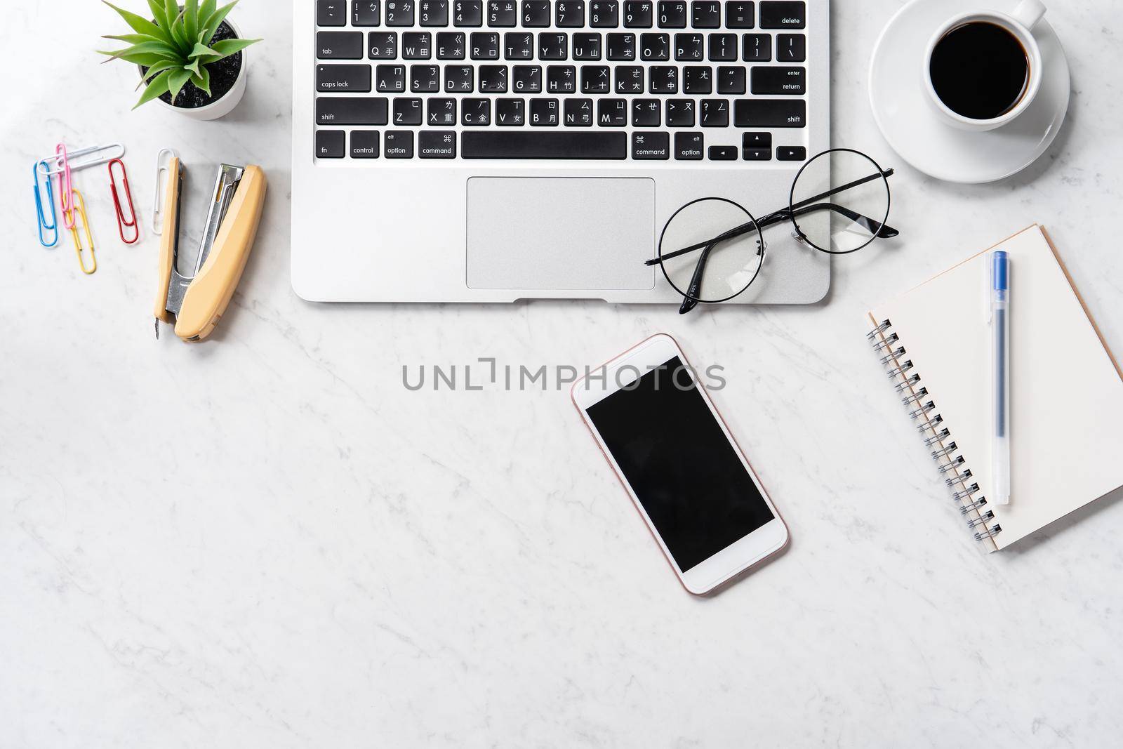 Stylized marble office working desk with smartphone, laptop, glasses and coffee, workspace design, mock up, topview, flatlay, copyspace, closeup