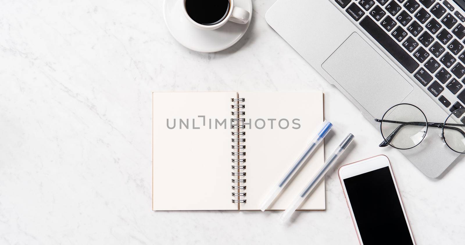 Stylized marble office working desk with smartphone, laptop, glasses and coffee, workspace design, mock up, topview, flatlay, copyspace, closeup