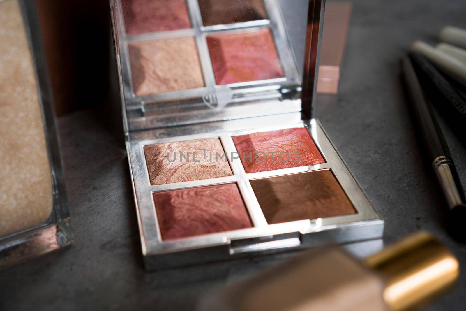 Eye shadow palette in rose gold and nude colors closeup. Makeup cosmetics. Selective focus.