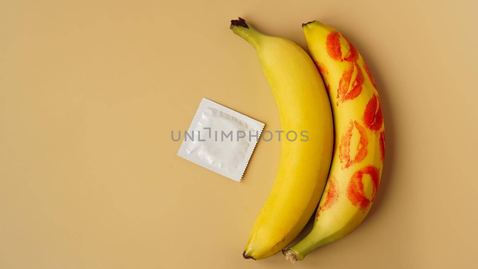 Condoms and two bananas with traces of red lipstick, concept of contraceptives and the prevention of venereal diseases.