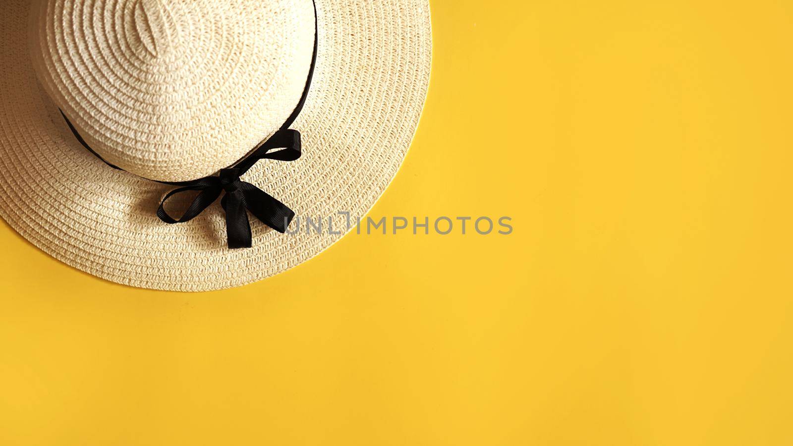 Summer straw hat on yellow background top view flat lay copy space. Summer travel vacation concept, single item. Female accessory, summer background