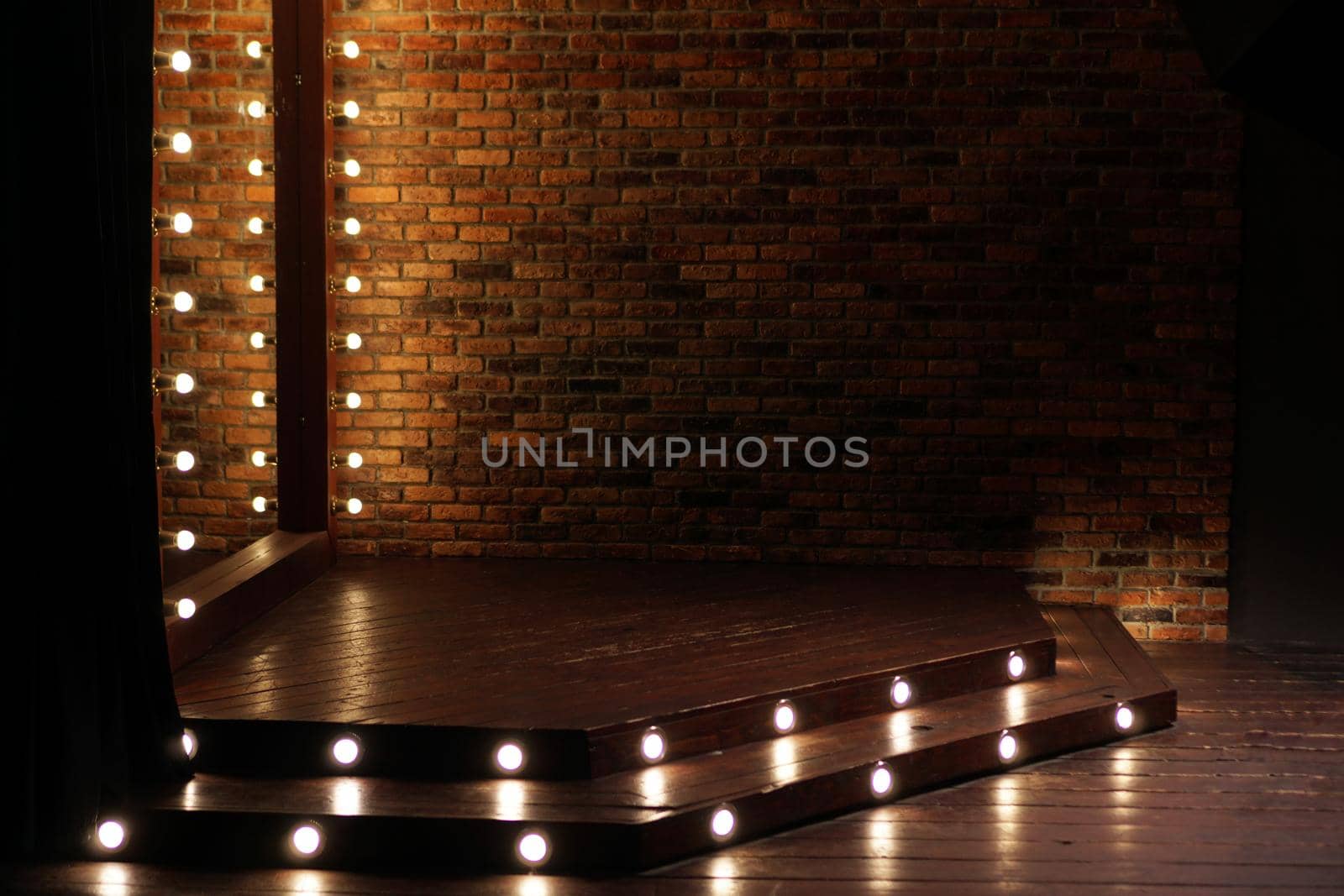 Podium with bulbs. Loft style interior with brick wall and mirror