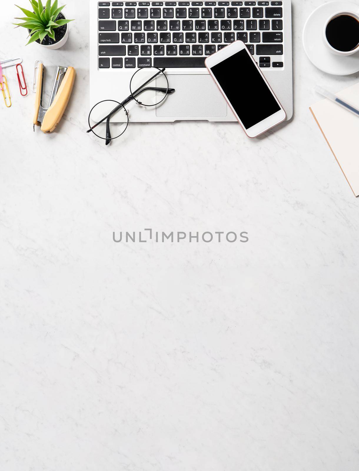 Stylized marble office working desk with smartphone, laptop, glasses and coffee, workspace design, mock up, topview, flatlay, copyspace, closeup