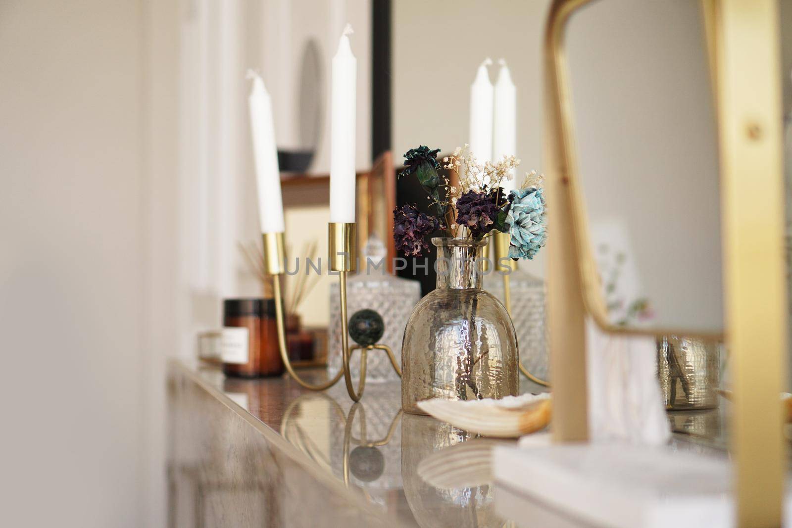 Home interior decor. Glass jar with dried flowers, vase and candle. Living room decoration.