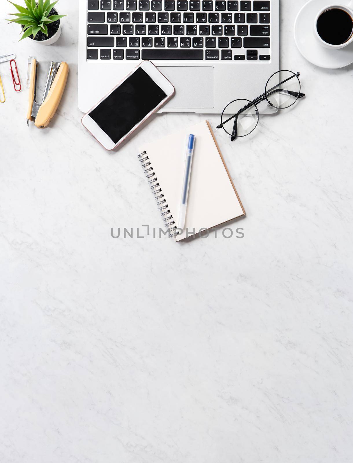 Stylized marble office working desk with smartphone, laptop, glasses and coffee, workspace design, mock up, topview, flatlay, copyspace, closeup
