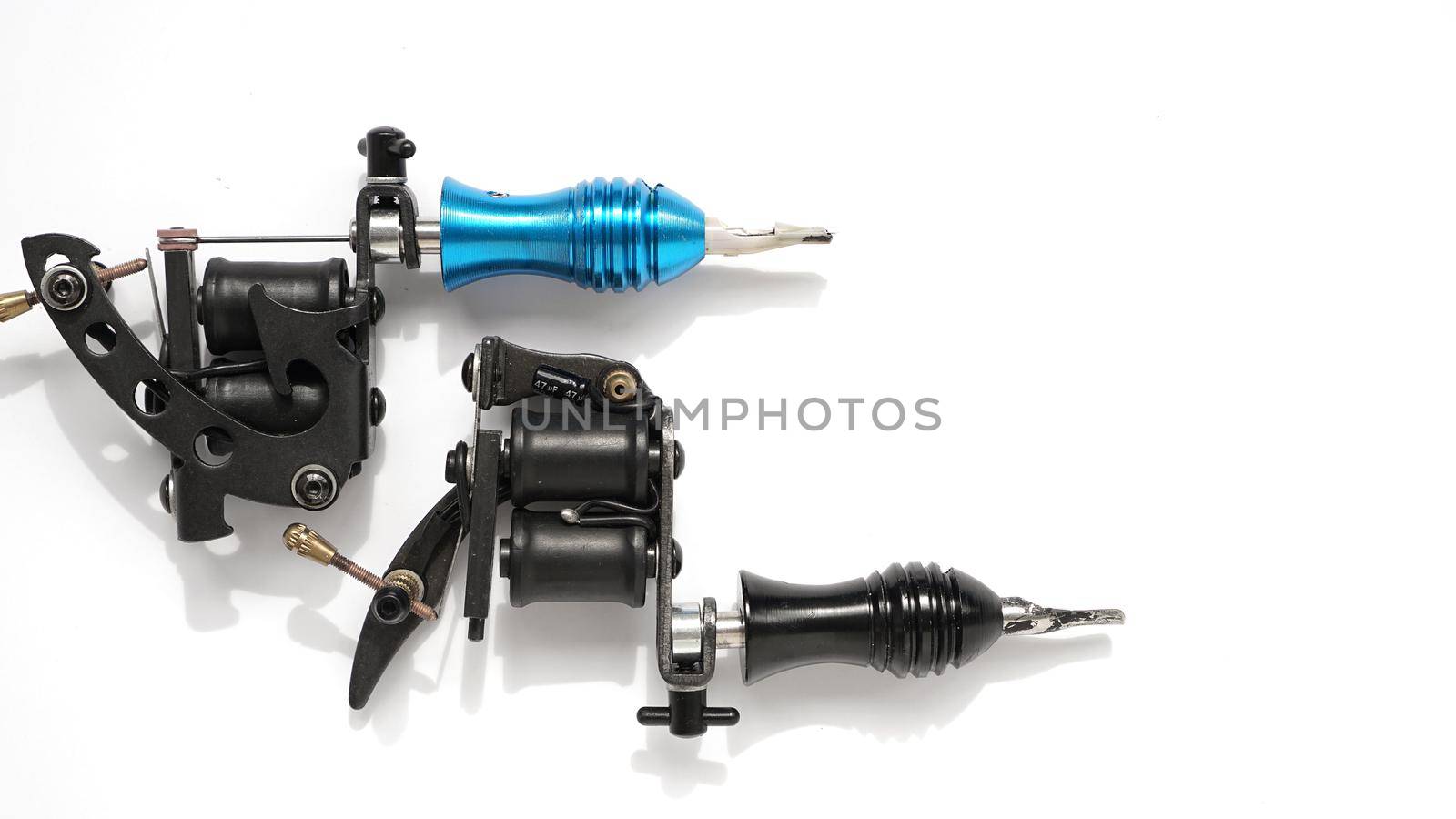 Two tattoo machines on a white background - tattoo industry -space for text