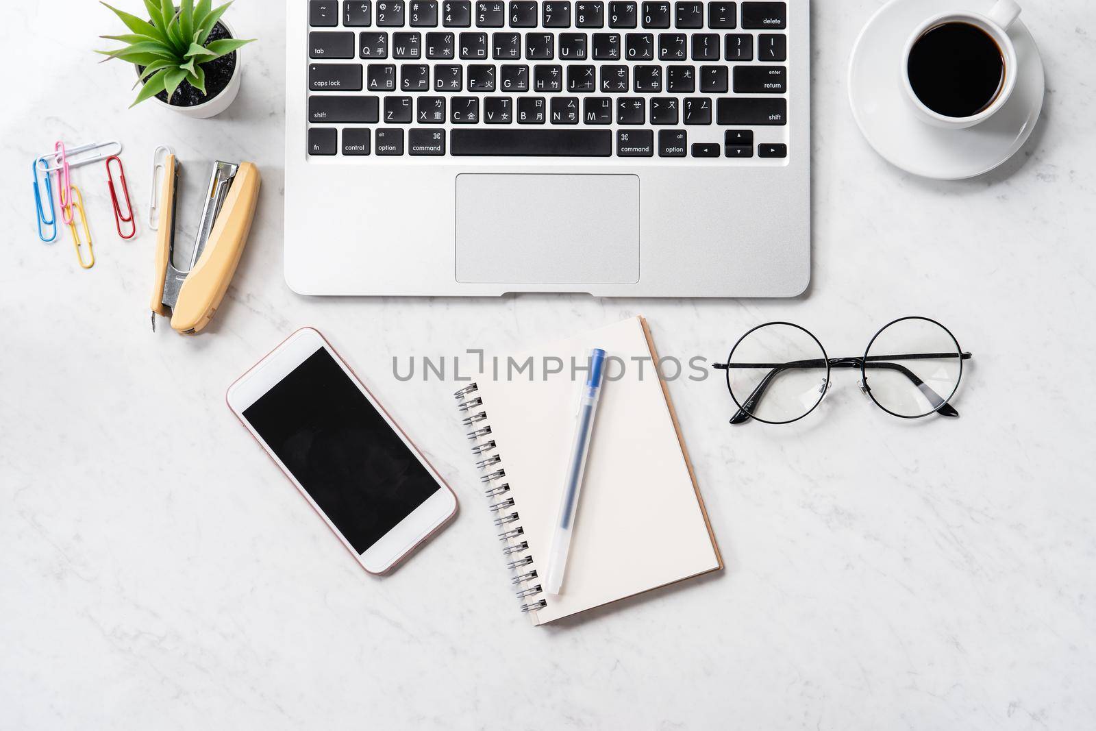 Stylized marble office working desk with smartphone, laptop, glasses and coffee, workspace design, mock up, topview, flatlay, copyspace, closeup