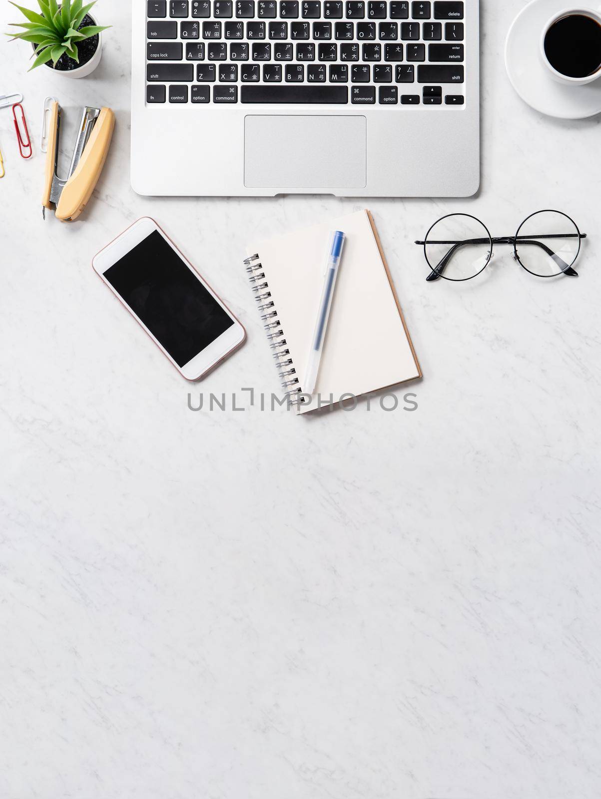 Stylized marble office working desk with smartphone, laptop, glasses and coffee, workspace design, mock up, topview, flatlay, copyspace, closeup