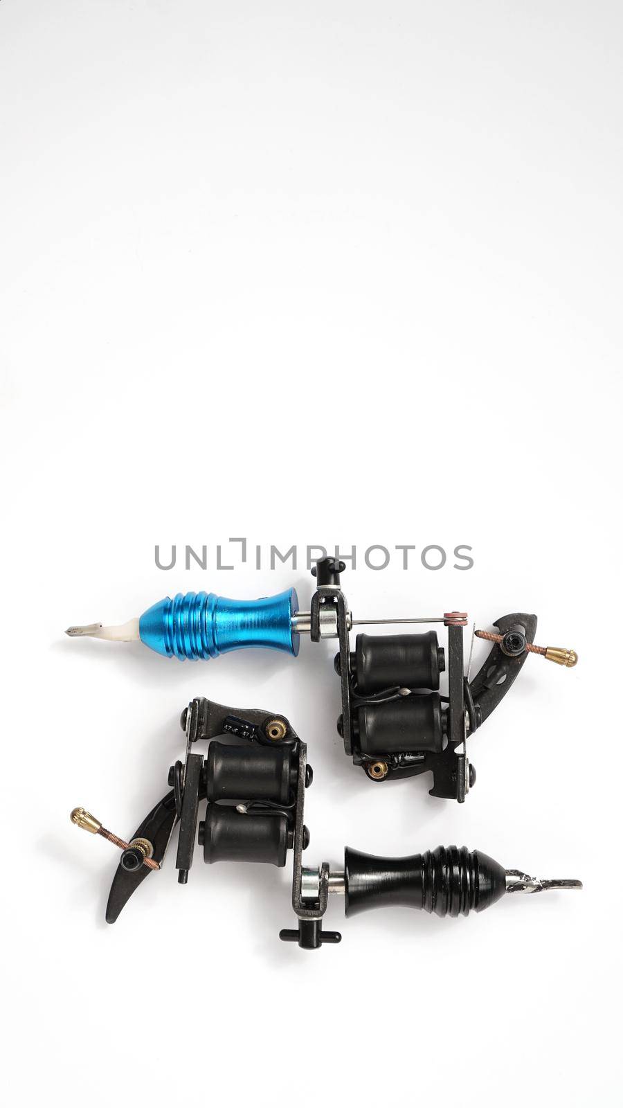 Two tattoo machines on a white background - vertical photo- tattoo industry