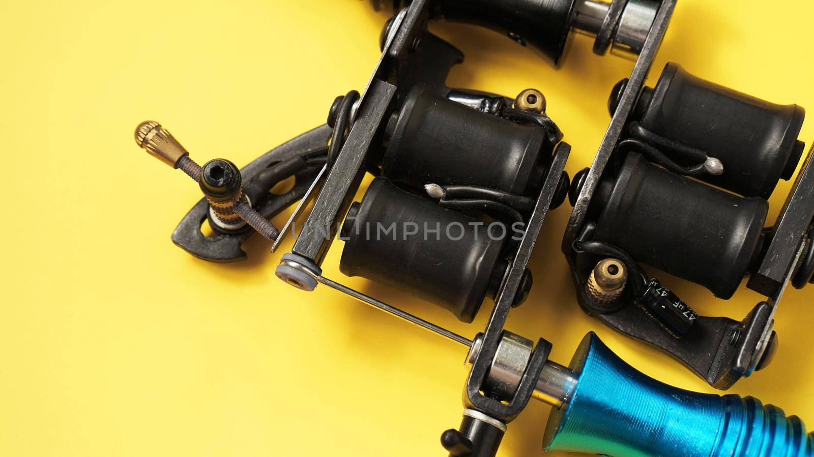 Two tattoo machines on a yellow background - tattoo industry