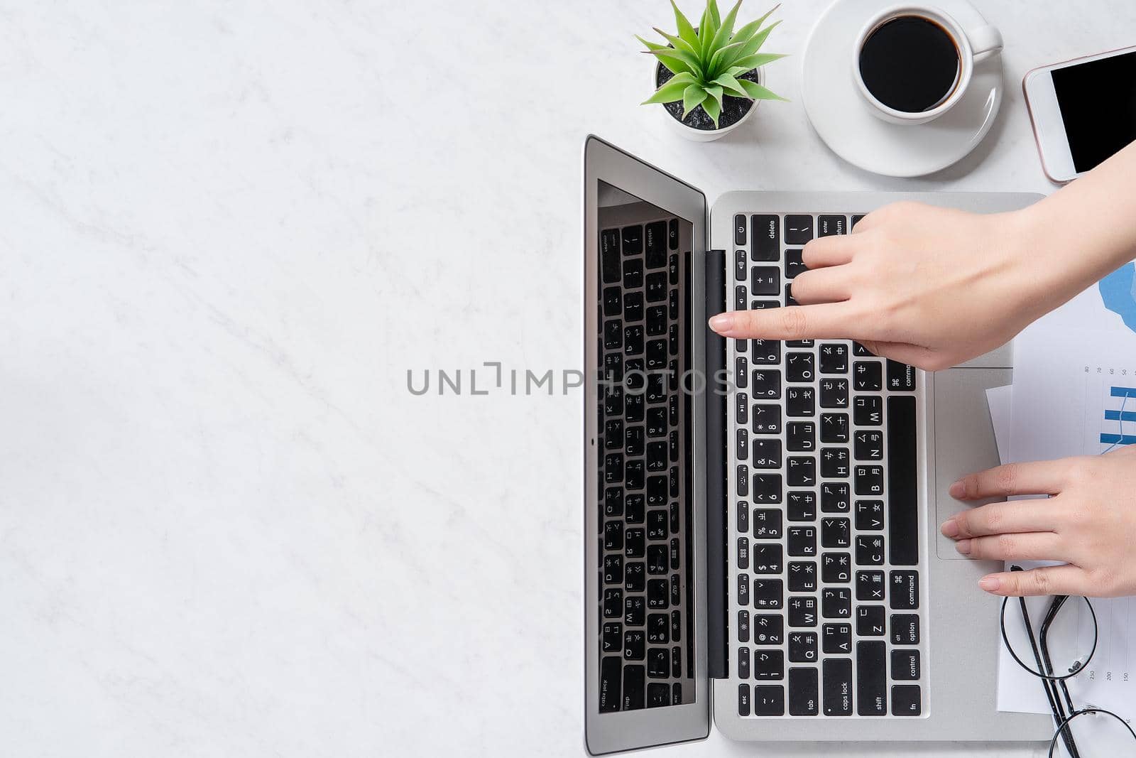 A woman is doing a online payment or shopping, mock up credit card and mobile phone on office desk isolated on beautiful fashion marble background, topview, flatlay, copyspace.