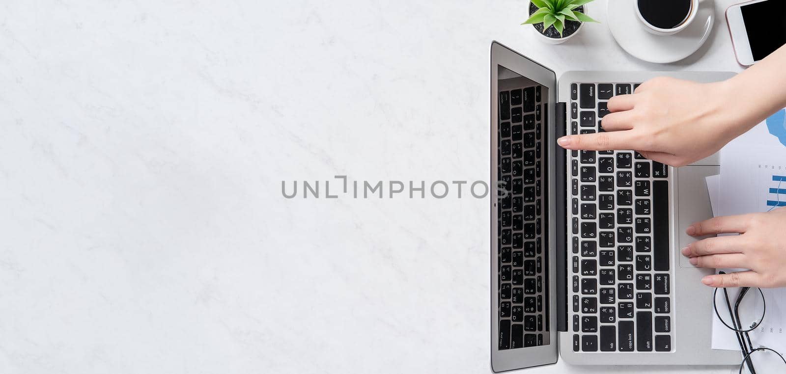 A woman is doing a online payment or shopping, mock up credit card and mobile phone on office desk isolated on beautiful fashion marble background, topview, flatlay, copyspace. by ROMIXIMAGE