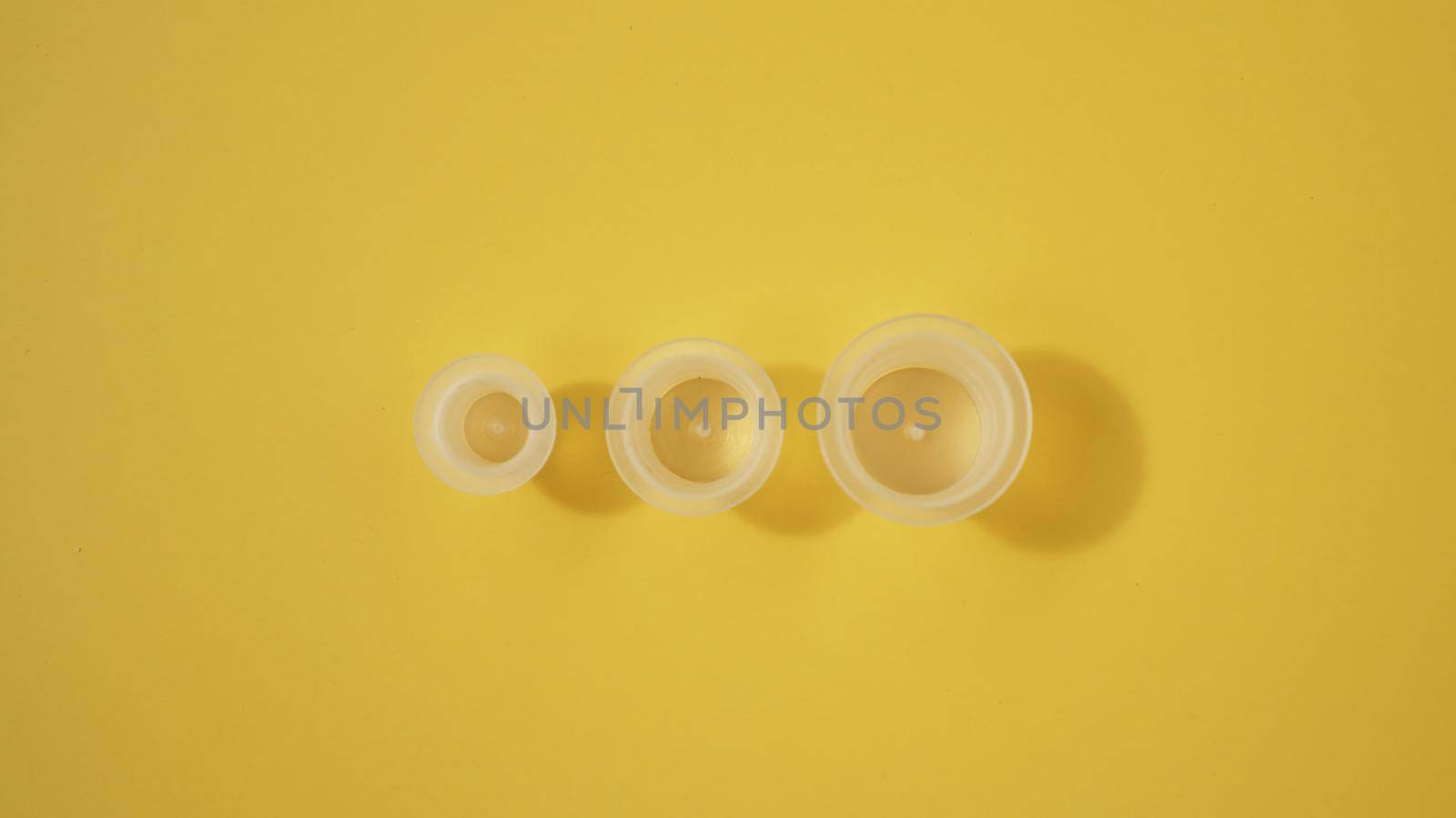 Three ink plastic caps on yellow background - tattoo concept