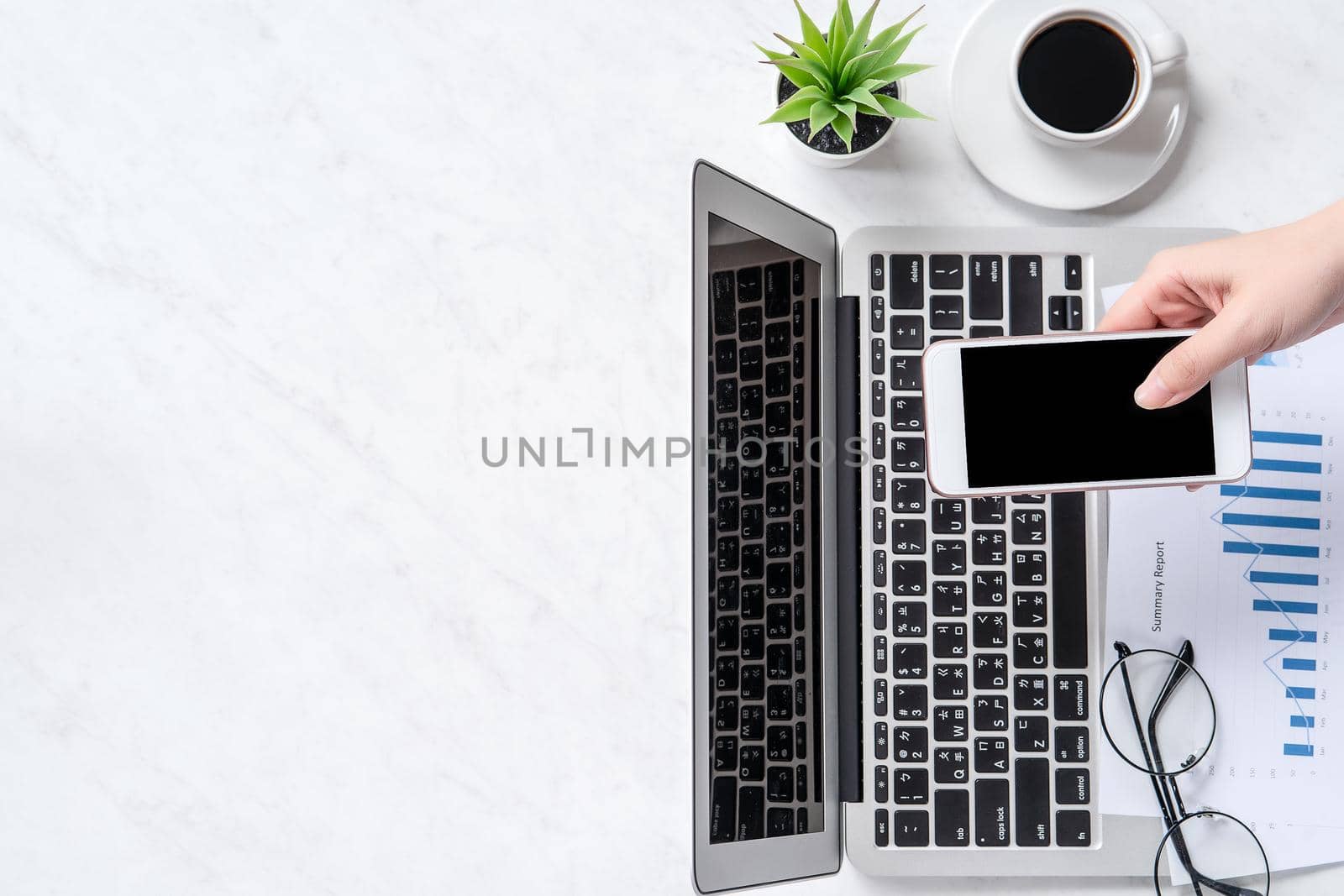 A woman is doing a online payment or shopping, mock up credit card and mobile phone on office desk isolated on beautiful fashion marble background, topview, flatlay, copyspace.