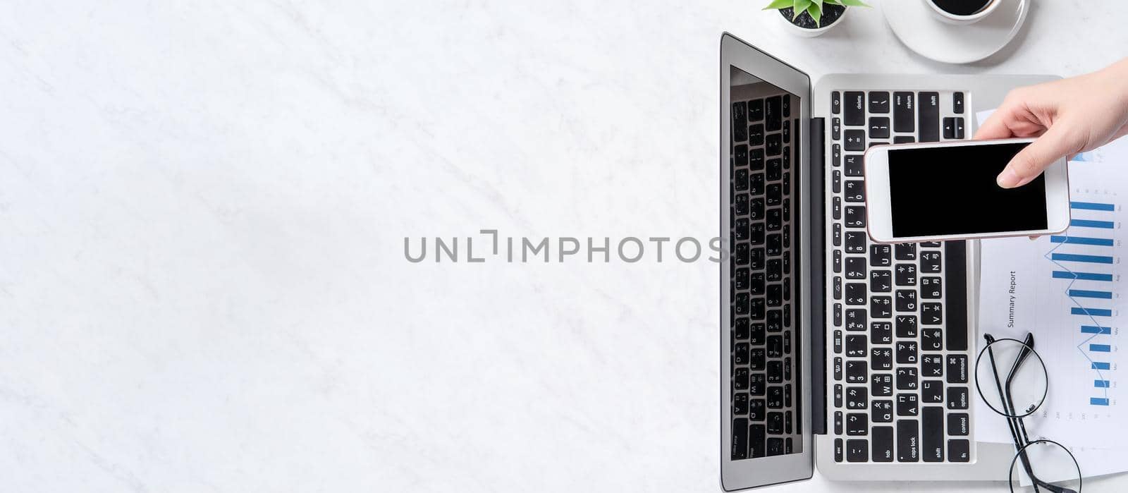 A woman is doing a online payment or shopping, mock up credit card and mobile phone on office desk isolated on beautiful fashion marble background, topview, flatlay, copyspace. by ROMIXIMAGE