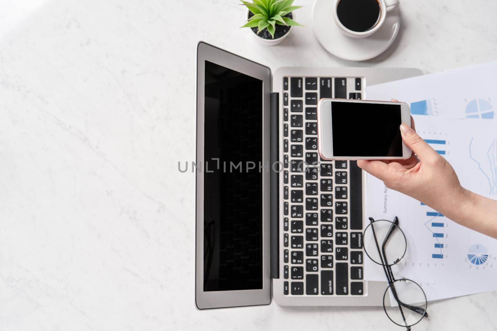 A woman is doing a online payment or shopping, mock up credit card and mobile phone on office desk isolated on beautiful fashion marble background, topview, flatlay, copyspace.
