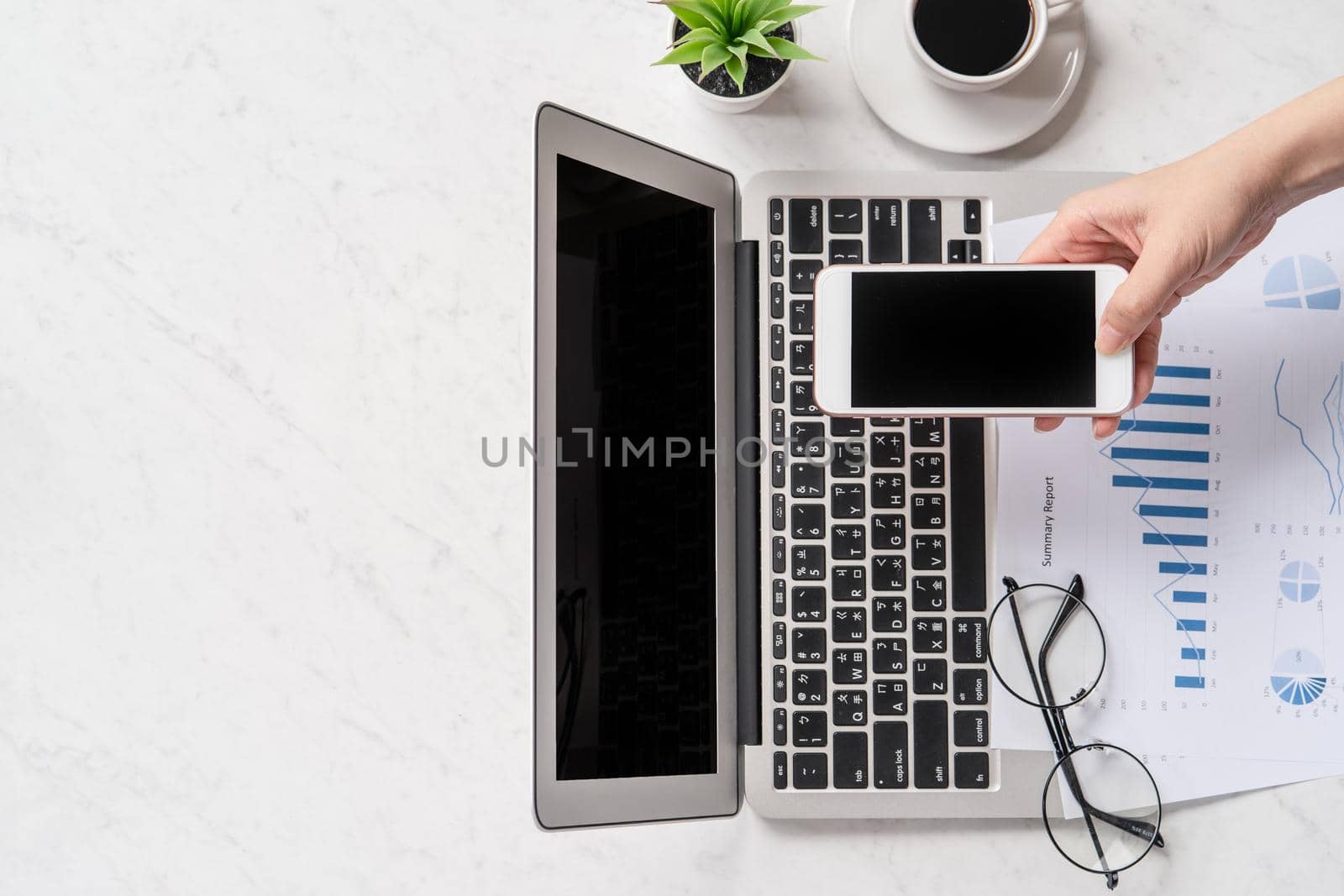 A woman is doing a online payment or shopping, mock up credit card and mobile phone on office desk isolated on beautiful fashion marble background, topview, flatlay, copyspace.