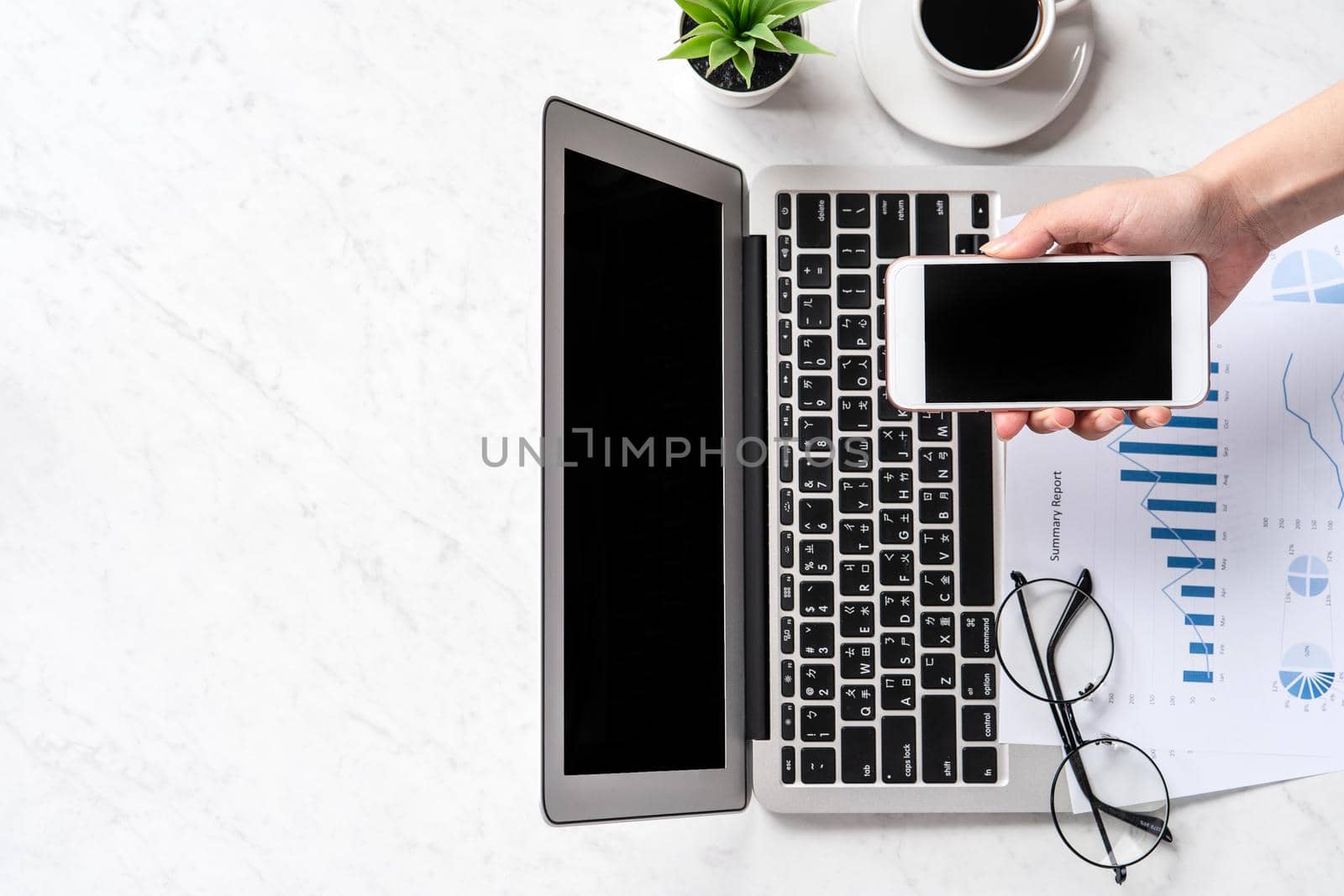 A woman is doing a online payment or shopping, mock up credit card and mobile phone on office desk isolated on beautiful fashion marble background, topview, flatlay, copyspace.