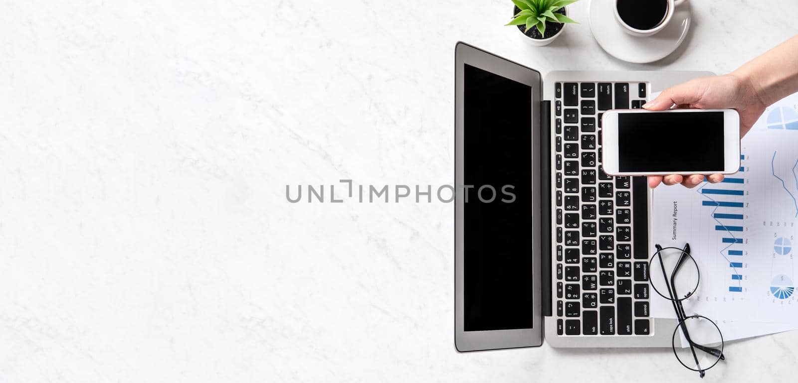 A woman is doing a online payment or shopping, mock up credit card and mobile phone on office desk isolated on beautiful fashion marble background, topview, flatlay, copyspace.