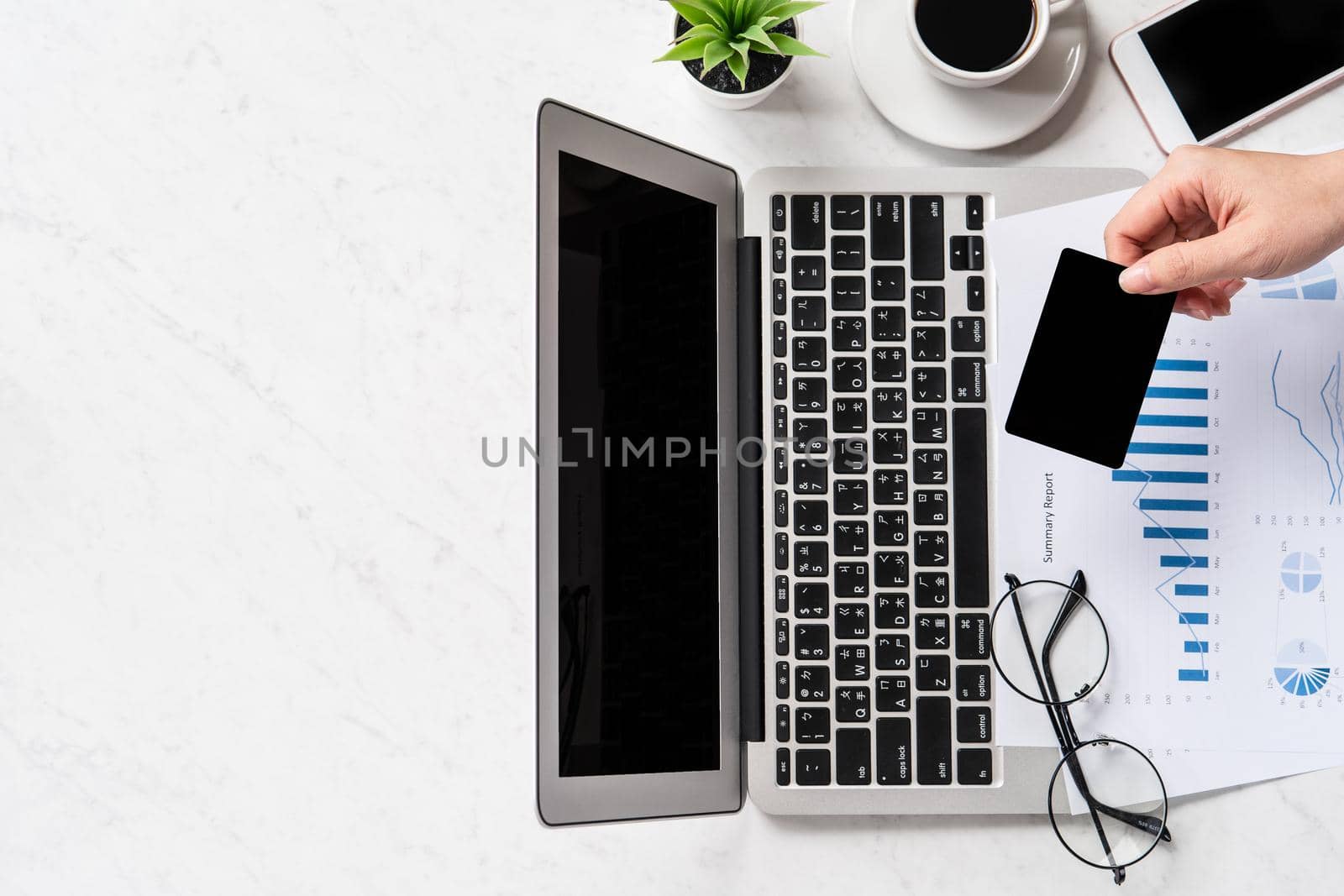 A woman is doing a online payment or shopping, mock up credit card and mobile phone on office desk isolated on beautiful fashion marble background, topview, flatlay, copyspace.