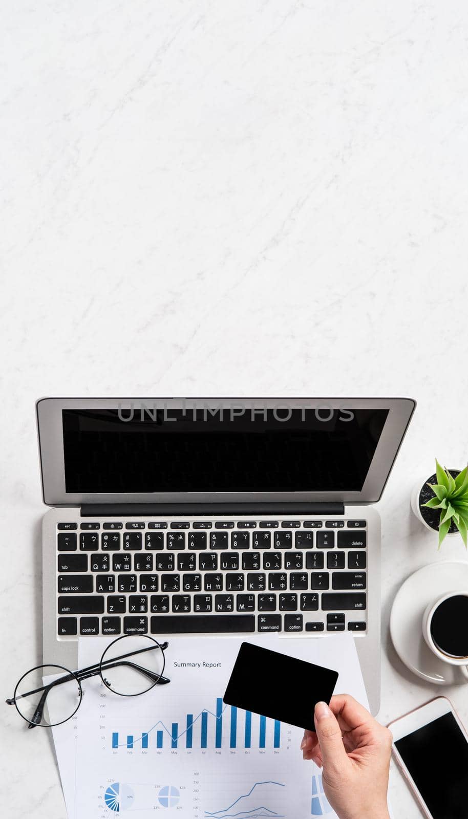 A woman is doing a online payment or shopping, mock up credit card and mobile phone on office desk isolated on beautiful fashion marble background, topview, flatlay, copyspace.
