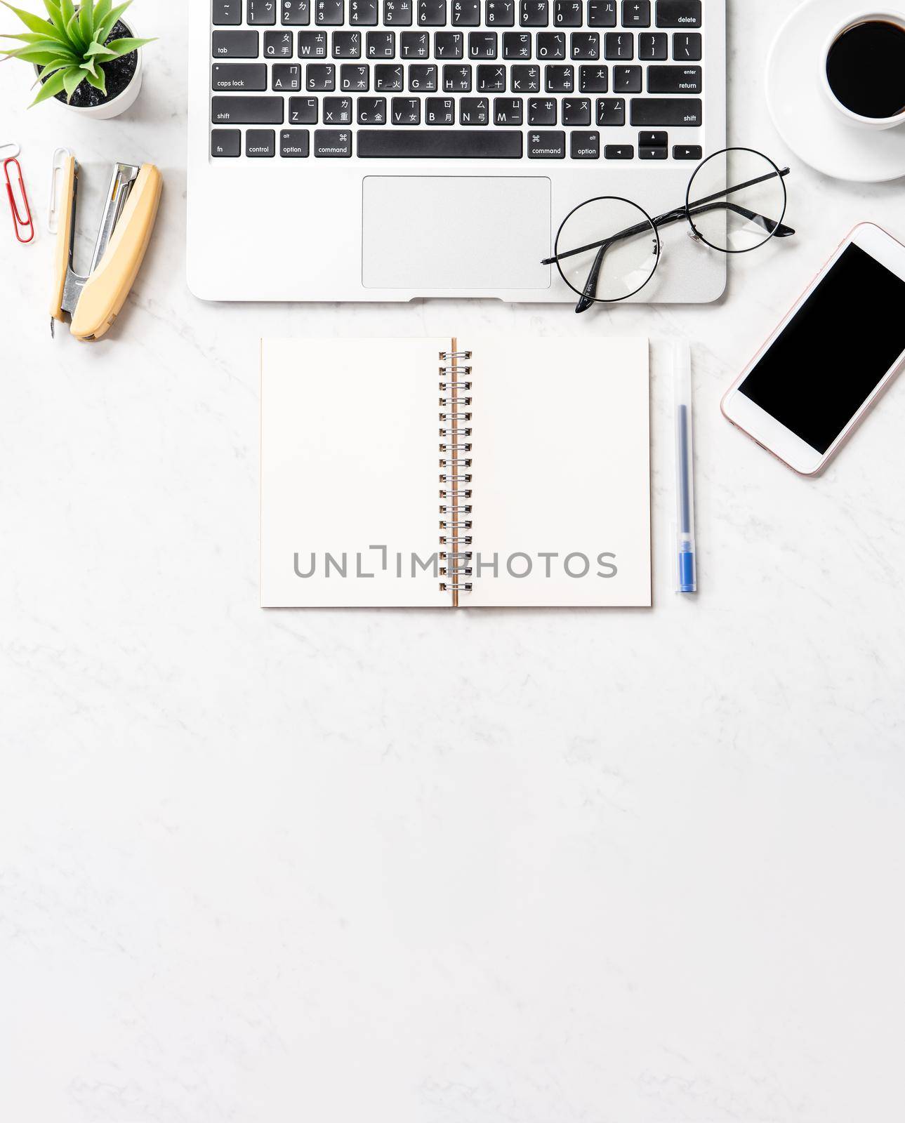 Stylized clean marble office working desk with smartphone, laptop, glasses and coffee, workspace design, mock up, topview, flatlay, copyspace, closeup