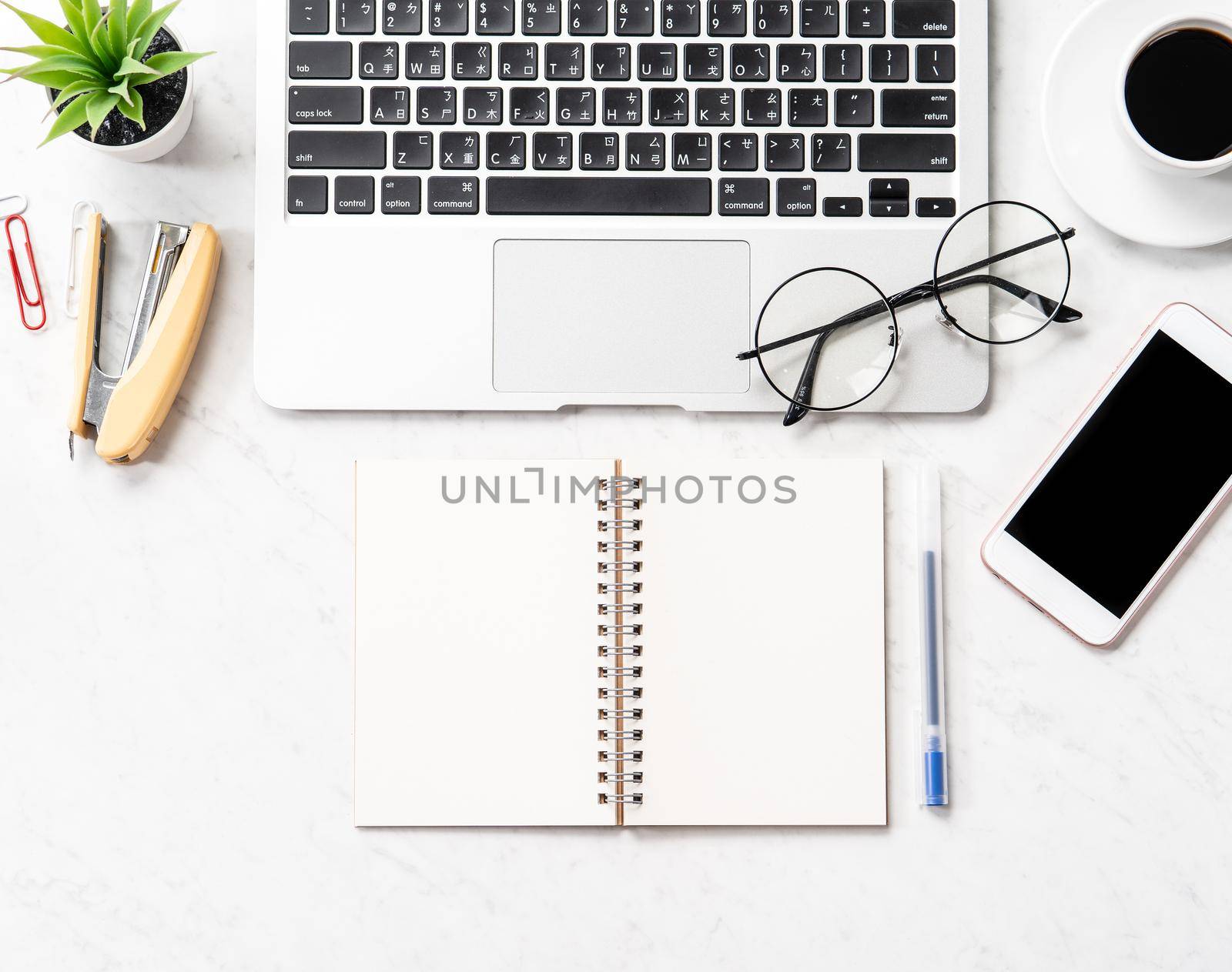 Stylized clean marble office working desk with smartphone, laptop, glasses and coffee, workspace design, mock up, topview, flatlay, copyspace, closeup