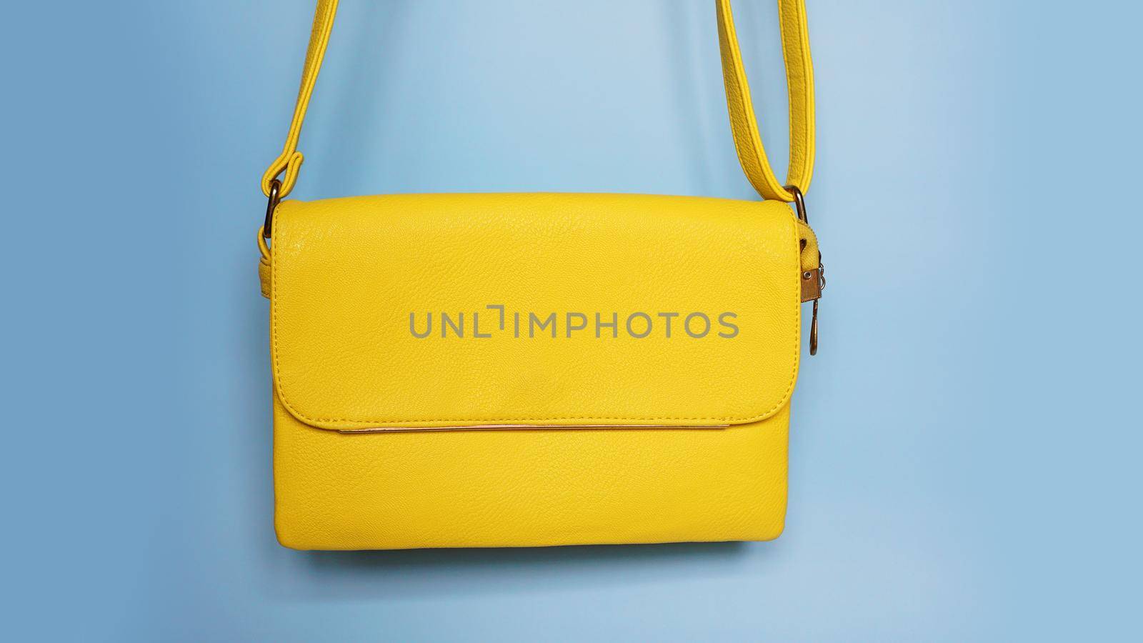 Yellow fashion female woman purse handbag on blue background