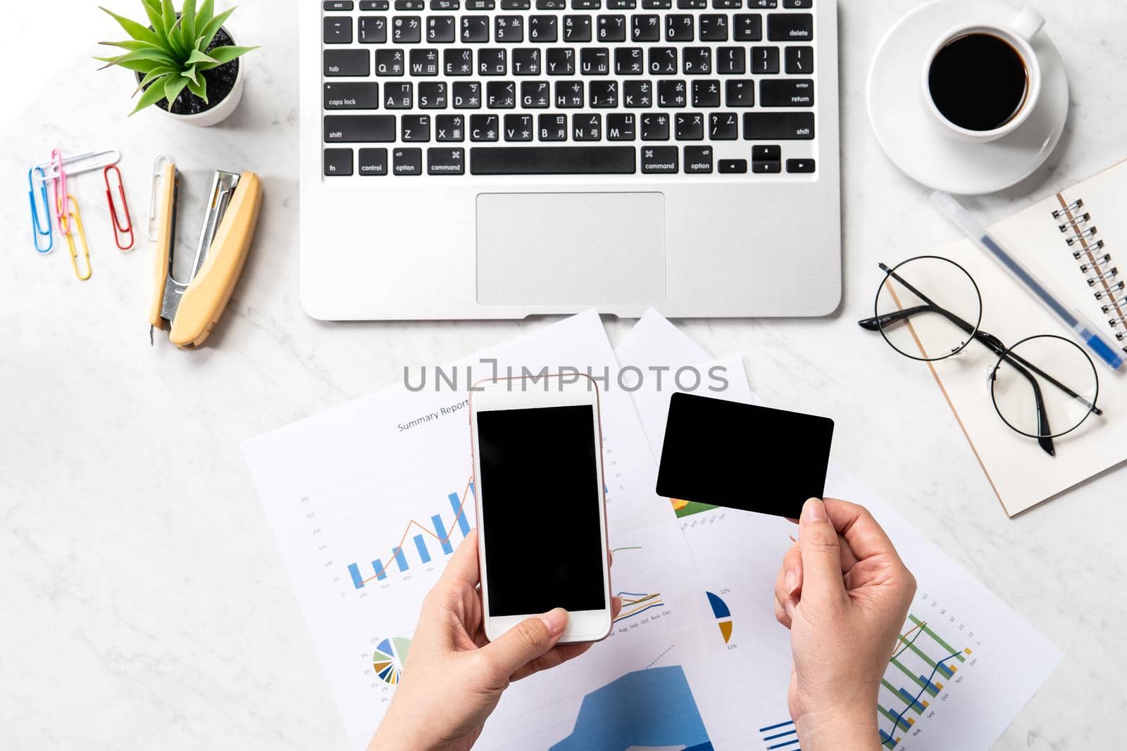 Online bill payment concept, a woman using mock up credit card and mobile cell phone on office desk isolated on beautiful fashion marble background, copy space, topview, flatlay, closeup