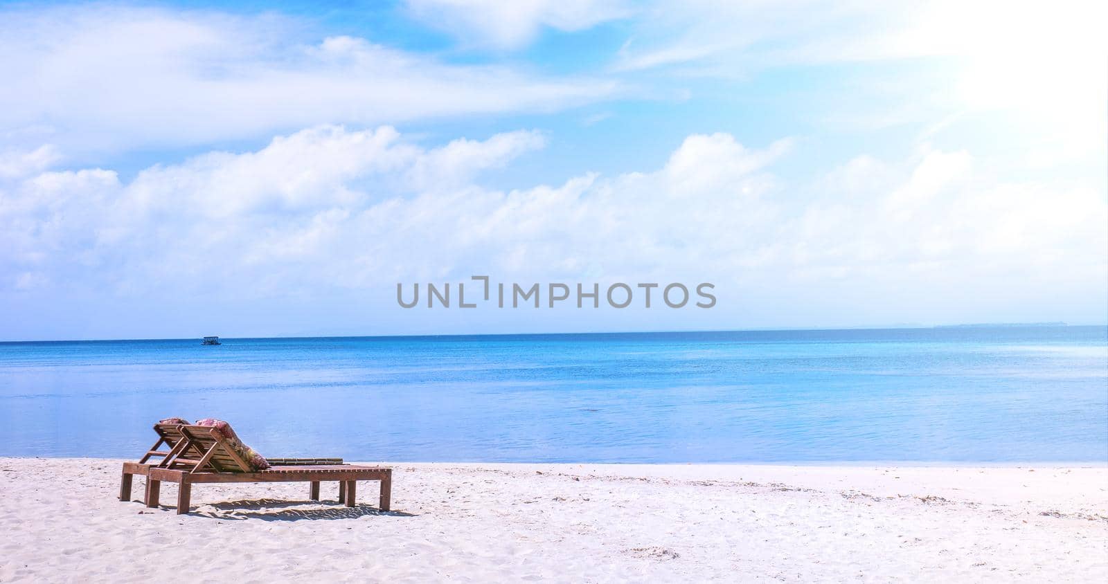 Chairs on the amazing beautiful sandy beach near the ocean with blue sky. Concept of summer leisure calm vacation for a tourism idea. Empty copy space, inspiration of tropical landscape