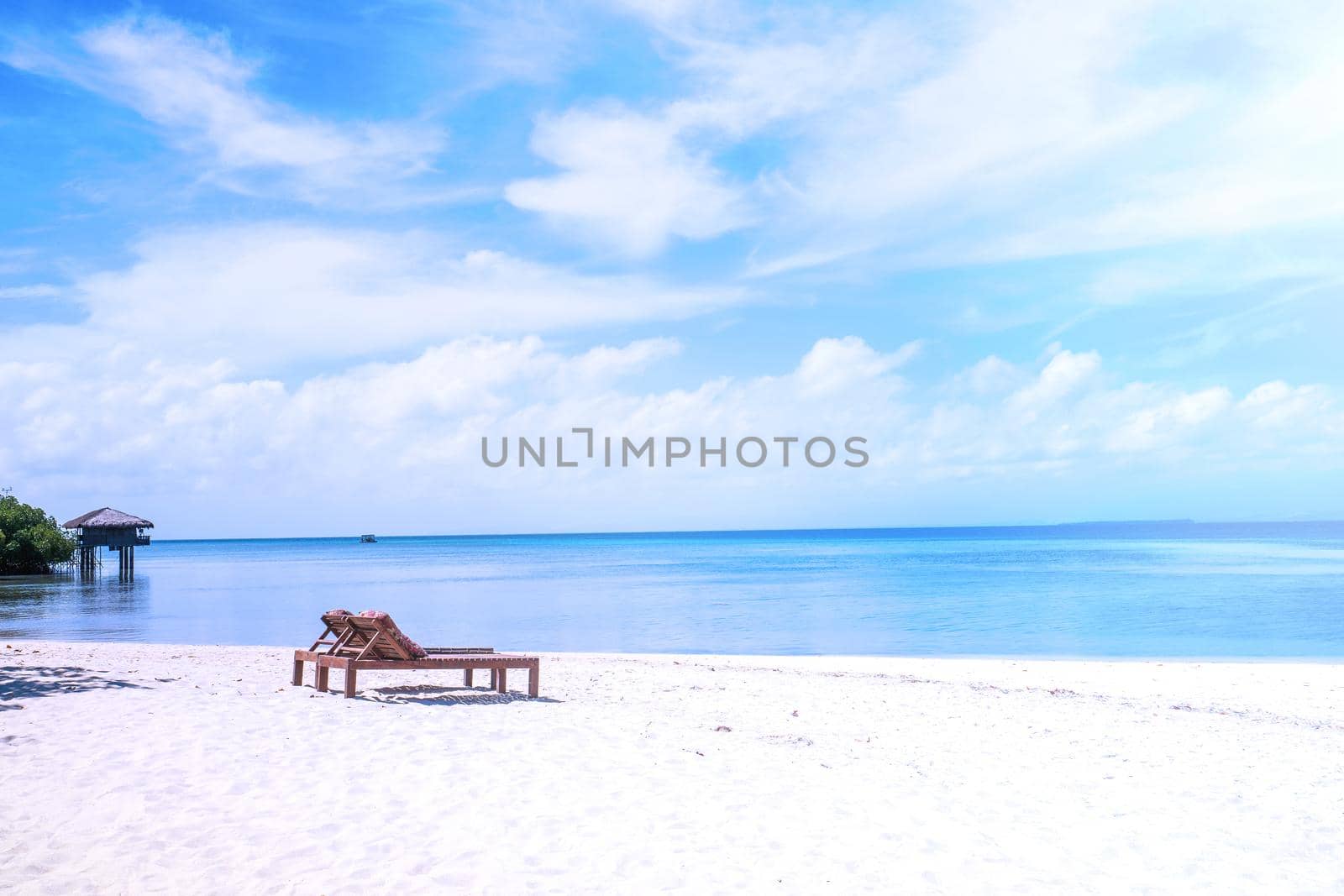 Chairs on the amazing beautiful sandy beach near the ocean with blue sky. Concept of summer leisure calm vacation for a tourism idea. Empty copy space, inspiration of tropical landscape