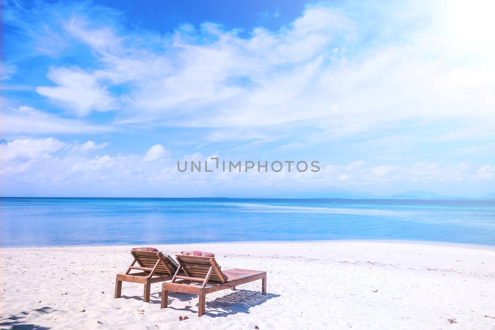 Chairs on the amazing beautiful sandy beach near the ocean with blue sky. Concept of summer leisure calm vacation for a tourism idea. Empty copy space, inspiration of tropical landscape