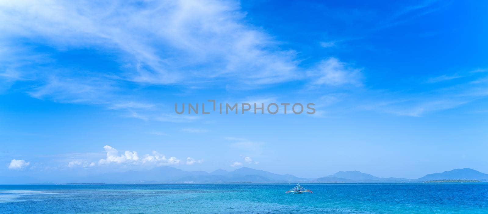 Beautiful ocean scene view isolated with light blue sky background, concept of vacation and sea travel, copy space
